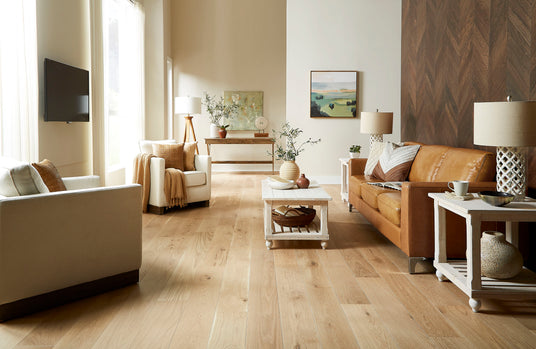 A softly styled living room with warm oak flooring