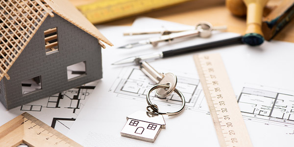 Home renovation plans and keys arranged on a worktable