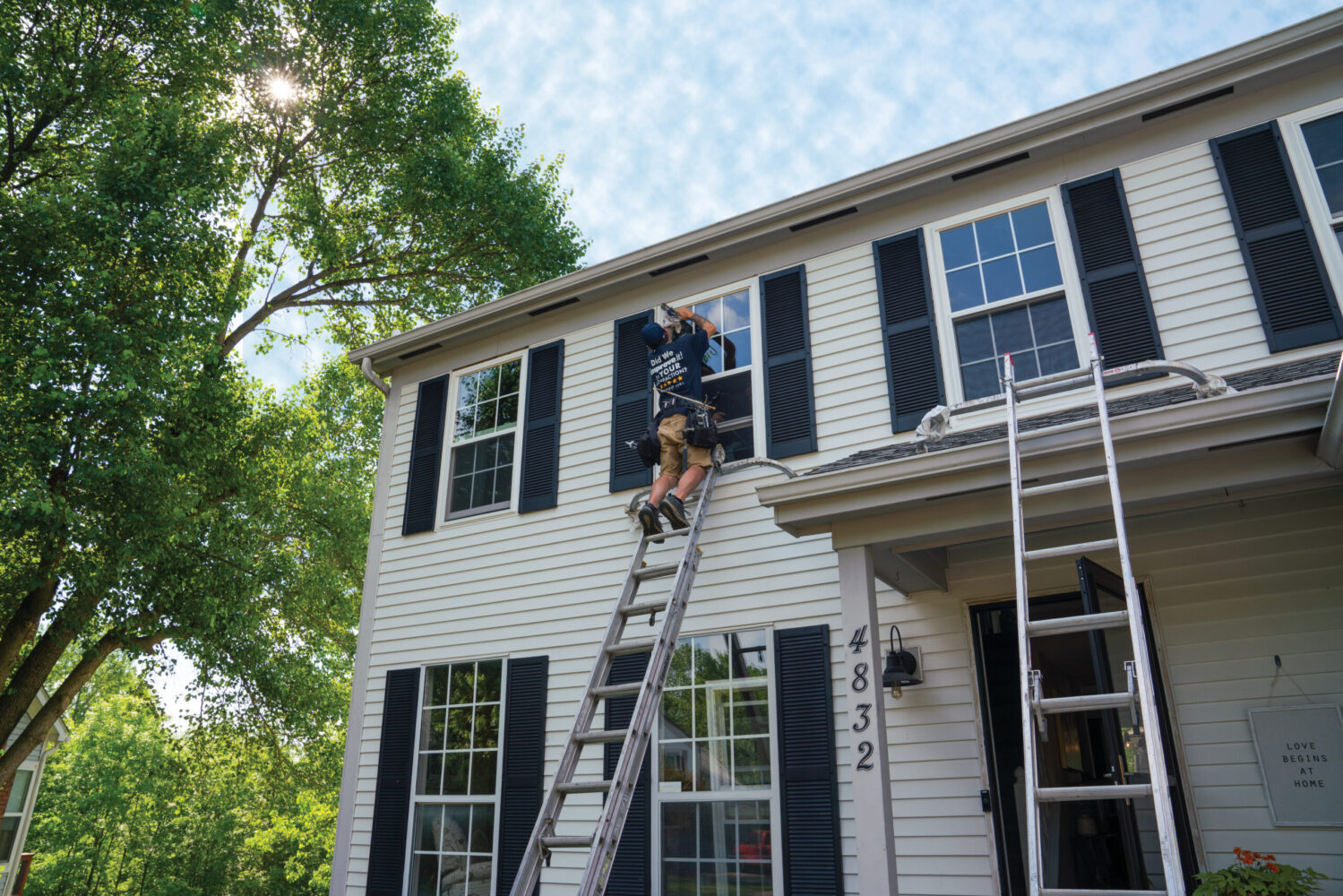 A roofing professional working carefully along a home roofline